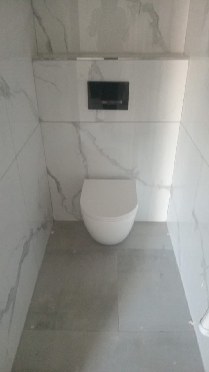A finished bathroom with a wall-hung toilet, installed by HDK Plumbing
